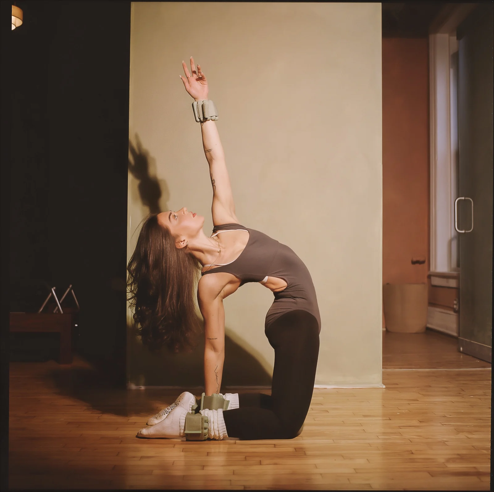 Julianna kneeling with one arm raised during a movement practice